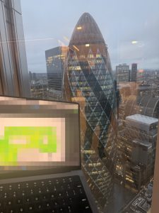 DataMove engineer conducting Ekahau wireless site survey with London skyline view from new skyscraper office